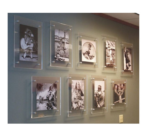 Photo of a gallery wall featuring floating frameless double panel acrylic picture frames with stand off hardware